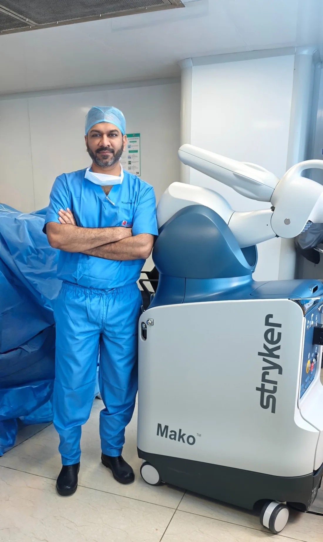 Dr Chetan M Dojode in theatre scrubs beside the Stryker MAKO robotic system, Bengaluru